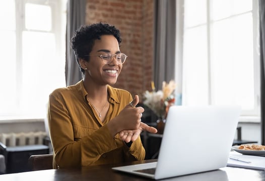 Una mujer hablando en lengua de señas, en una entrevista de trabajo virtual.